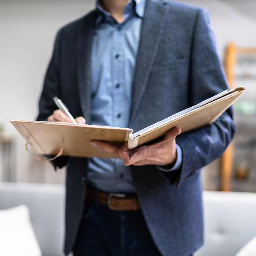 Man in suit writing into a book